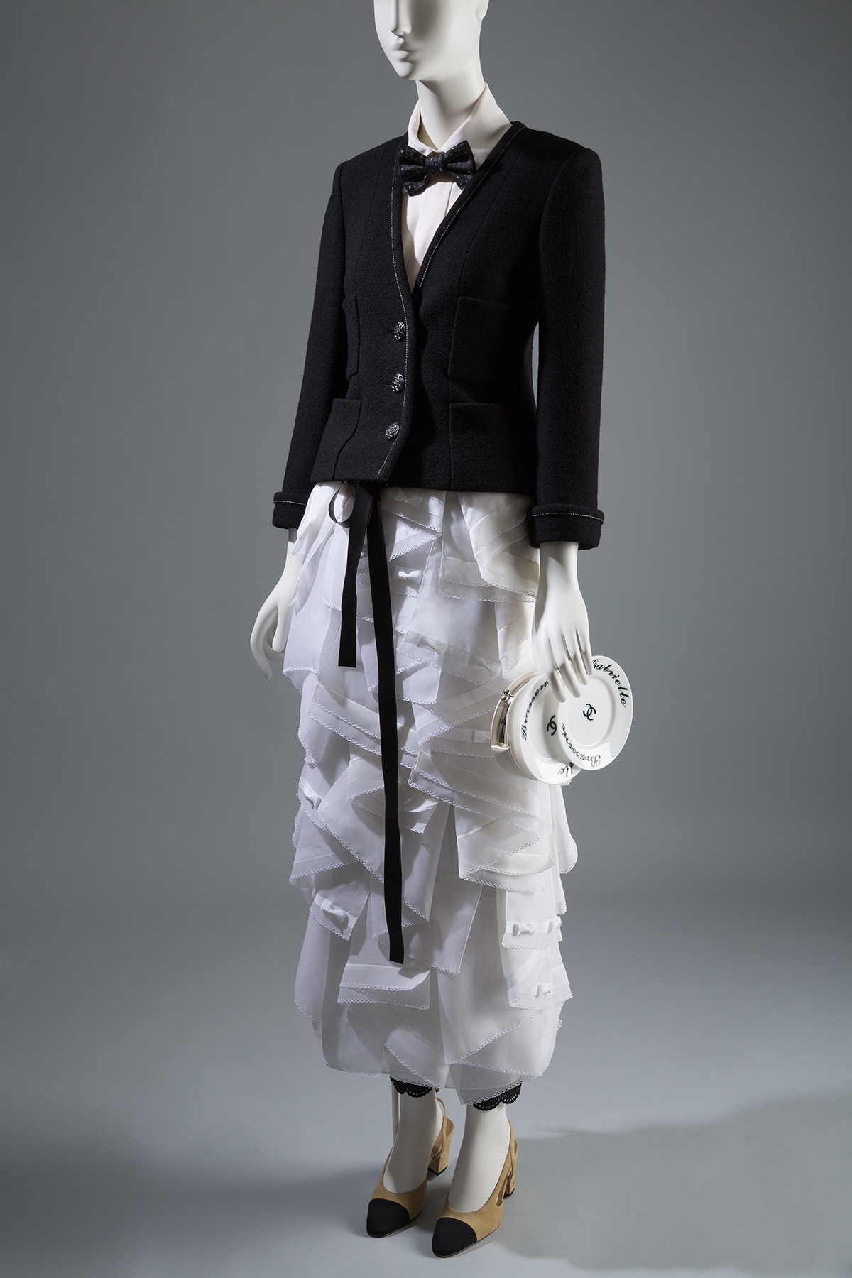 black button down vneck top with white ruffled skirt and small plate bag