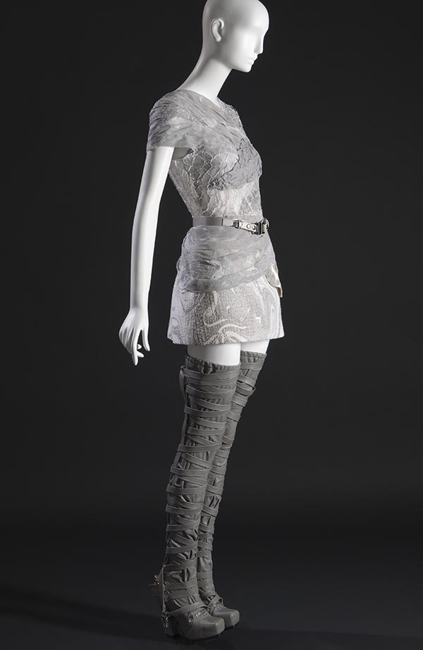 side view of silver ensemble with belt and high boots
