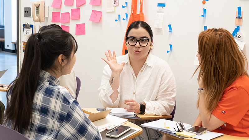 three students talking in class