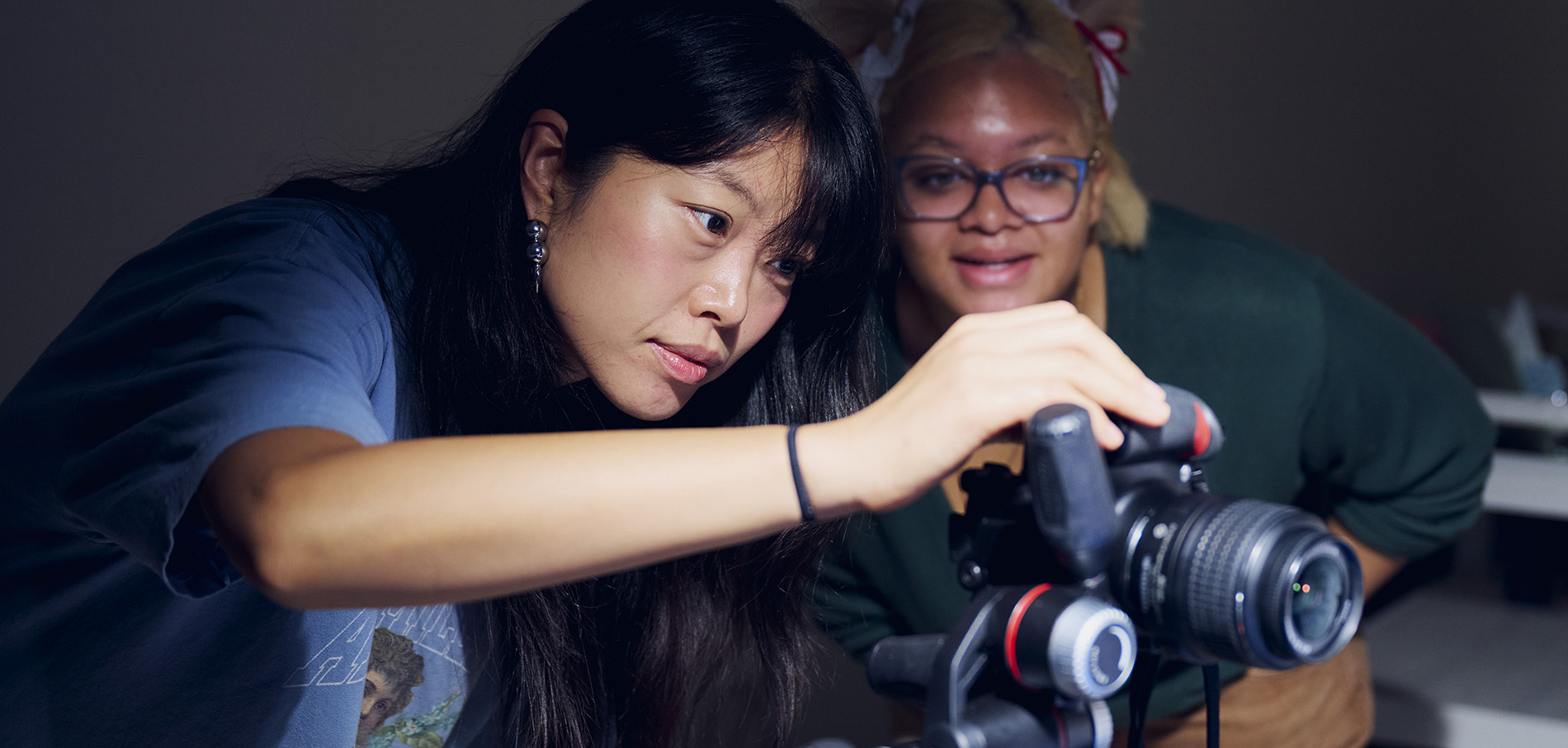 two students setting up a camera on a tripod