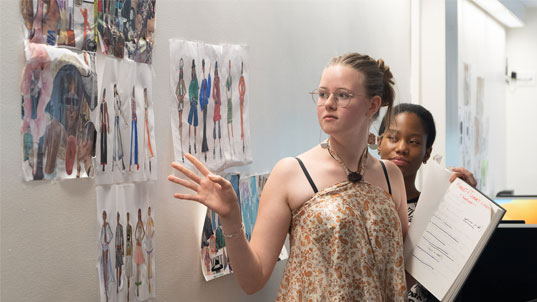 two students standing at visoin board