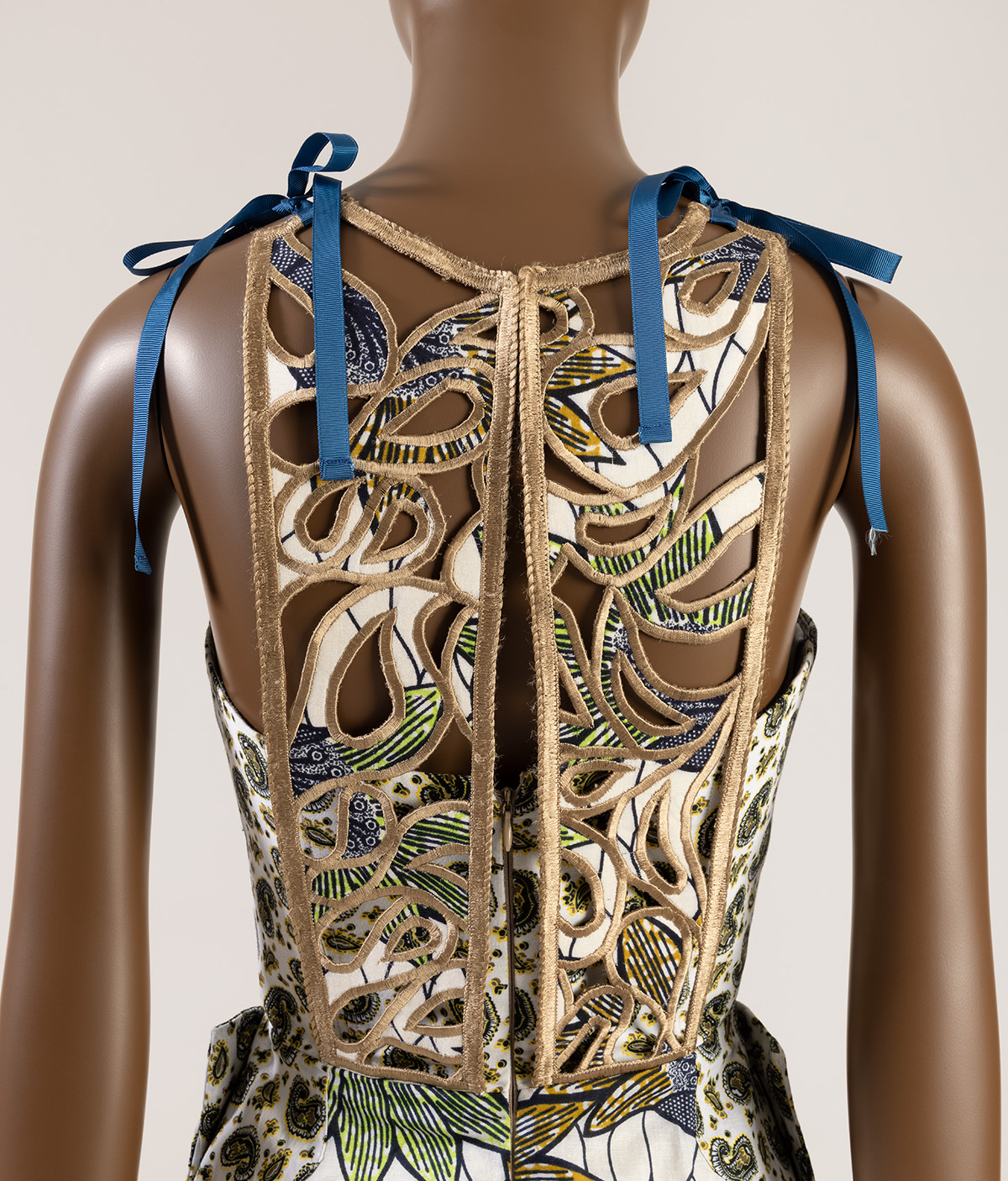back view of a dress with blue ribbons and cut out back