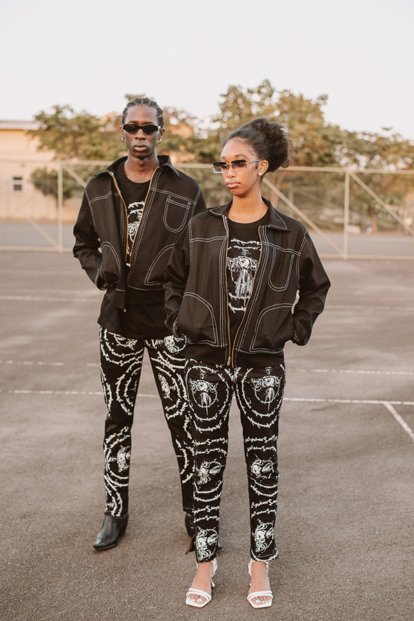 two Black models wearing black denim jackets with printed black pants