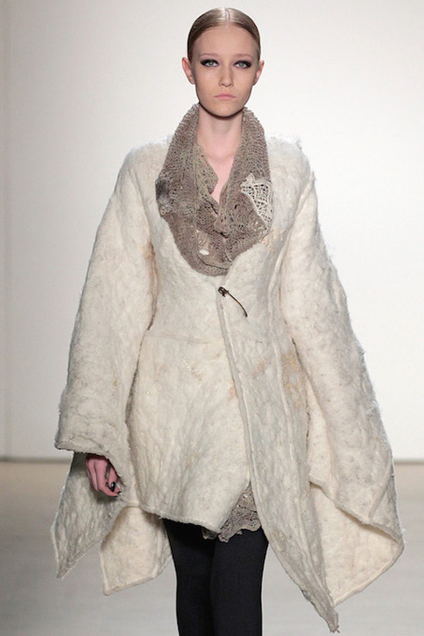 model wearing off white coat with brown collar