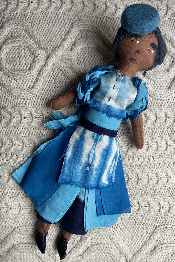 brown felt doll wearing a blue hat and matching dyed ensemble