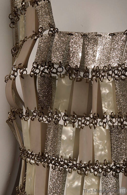 bust detail of dress made of glittery and metallic beige/gold tone rectangles chained together