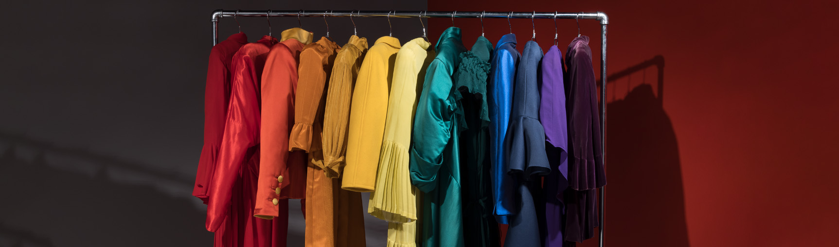 rack of clothes with distinctive sleeves arranged in the colors of the rainbow