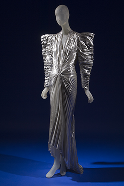 long evening dress in pleated silver metallic lamé with futuristic angular styling wide padded shoulders