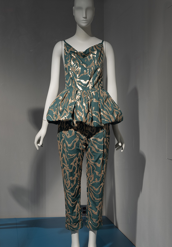 Mannequin wearing a halter top with a peplum and matching pants in a green fabric with gold pattern