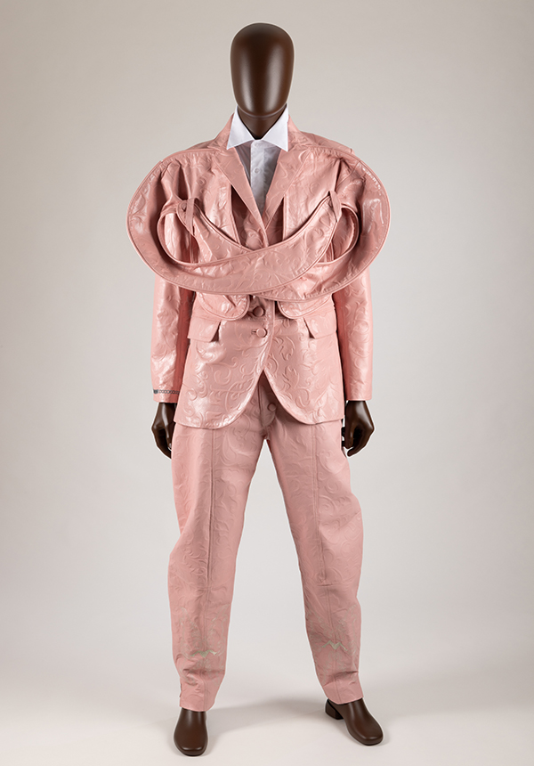 Mannequin in a pink tooled leather jacket and pants with added panels that add volume to the chest and shoulders